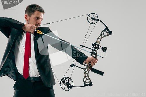 Image of Businessman aiming at target with bow and arrow, isolated on white background