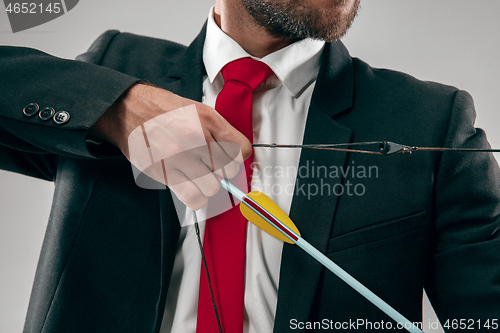 Image of Businessman aiming at target with bow and arrow, isolated on white background