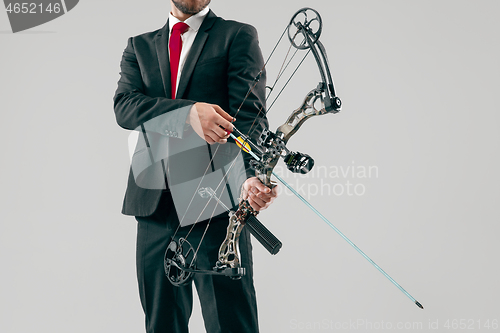 Image of Businessman aiming at target with bow and arrow, isolated on white background