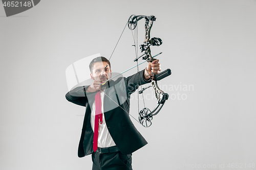 Image of Businessman aiming at target with bow and arrow, isolated on white background