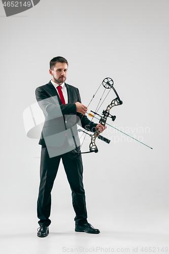 Image of Businessman aiming at target with bow and arrow, isolated on white background