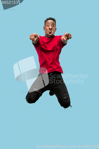 Image of Freedom in moving and forward motion. The happy surprised young afro man jumping