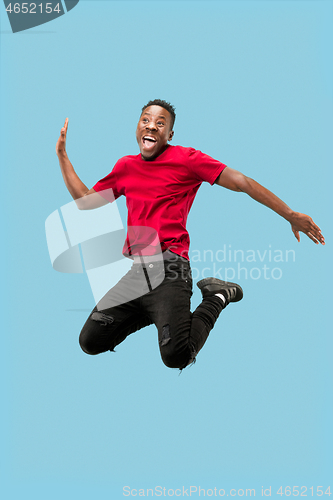 Image of Freedom in moving and forward motion. The happy surprised young afro man jumping