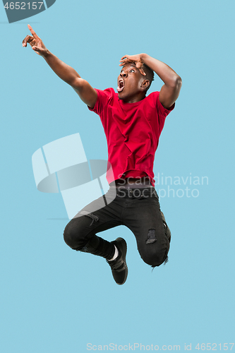 Image of Freedom in moving and forward motion. The happy surprised young afro man jumping