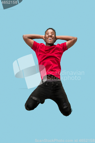 Image of Freedom in moving and forward motion. The happy surprised young afro man jumping