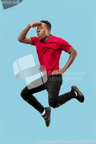 Image of Freedom in moving and forward motion. The happy surprised young afro man jumping