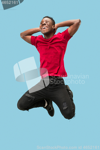 Image of Freedom in moving and forward motion. The happy surprised young afro man jumping