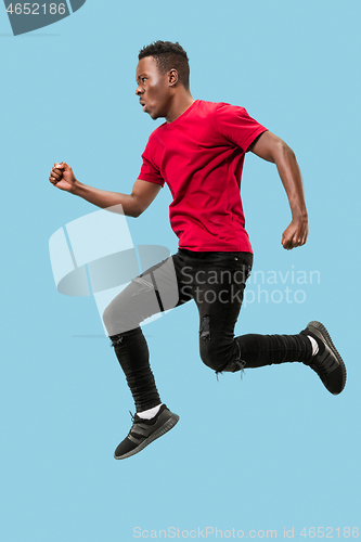 Image of Freedom in moving and forward motion. The happy surprised young afro man jumping