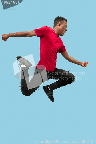 Image of Freedom in moving and forward motion. The happy surprised young afro man jumping