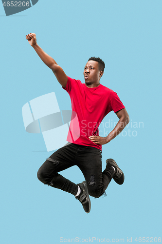 Image of Freedom in moving and forward motion. The happy surprised young afro man jumping