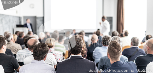 Image of I have a question. Group of business people sitting in conference hall. Businessman raising his arm. Conference and Presentation. Business and Entrepreneurship