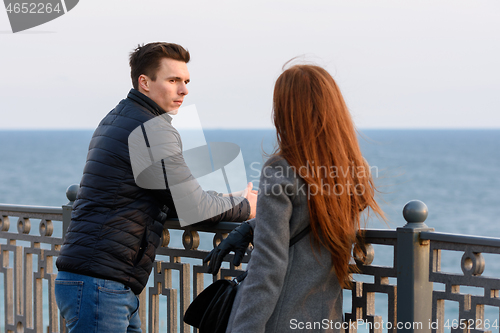 Image of Two young people discuss the situation on the beach