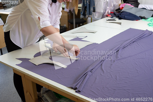 Image of cutting the matter on a large table in the workshop