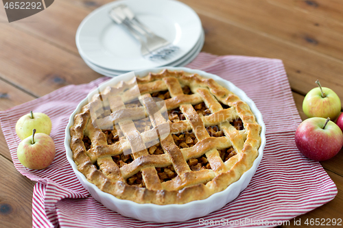 Image of apple pie in baking mold on wooden table