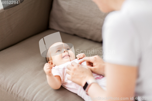 Image of close up of mother playing with baby at home