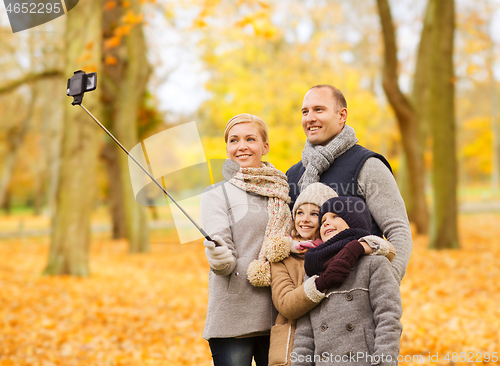 Image of happy family with smartphone and monopod in park
