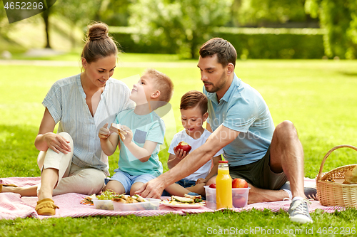 Image of happy family having picnic at summer park