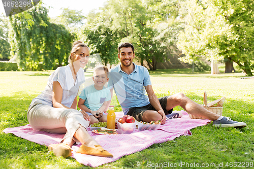 Image of happy family having picnic at summer park