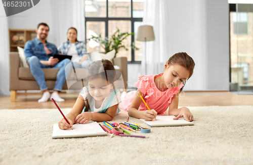 Image of happy sisters drawing in sketchbooks at home