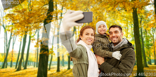 Image of family taking selfie by smartphone in autumn park