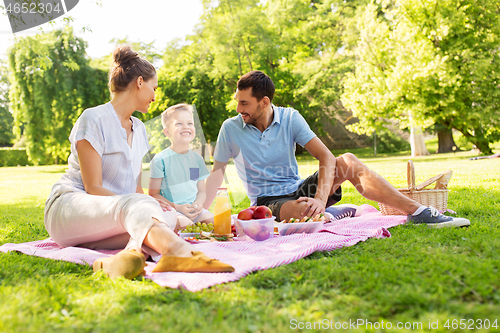 Image of happy family having picnic at summer park