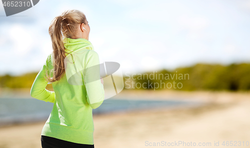 Image of woman with earphones running at park