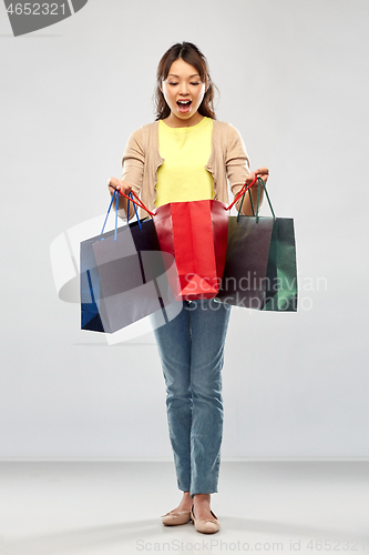 Image of happy asian woman with shopping bags