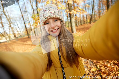 Image of happy girl taking selfie at autumn park
