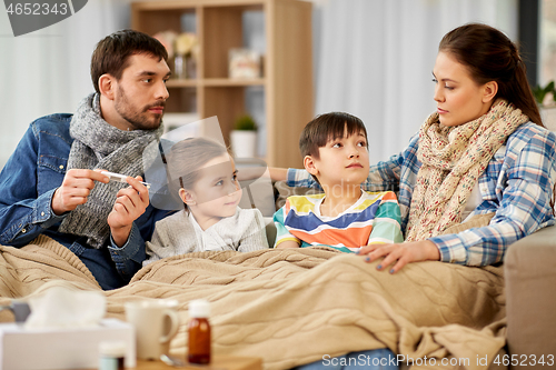 Image of family with ill children having fever at home