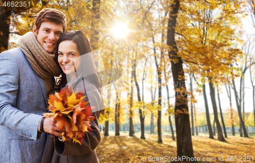 Image of smiling couple hugging in autumn park