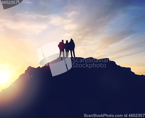 Image of group of travelers with backpacks over sunrise