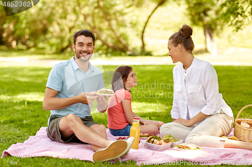 Image of happy family having picnic at summer park