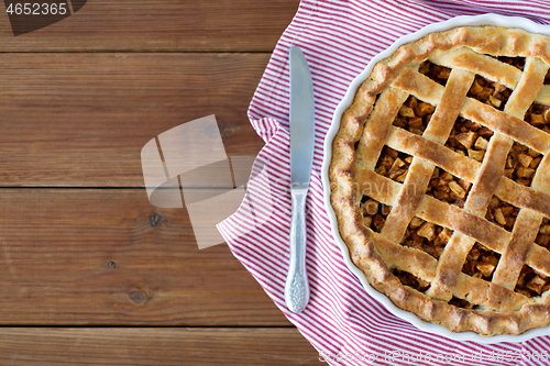 Image of close up of apple pie in baking mold and knife