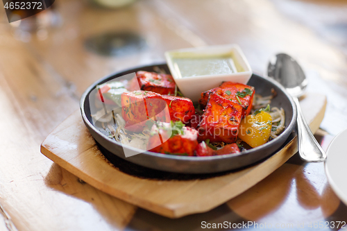 Image of close up of paneer tikka dish with sauce on table