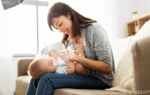 Image of happy young mother with little baby son at home