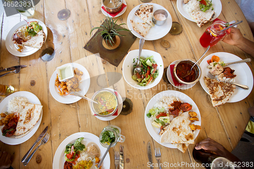 Image of african american friends eating at restaurant