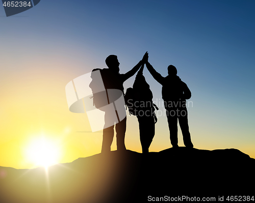 Image of travelers making high five over sunrise