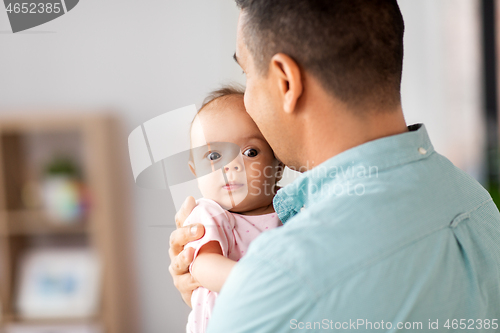 Image of middle aged father with baby daughter at home