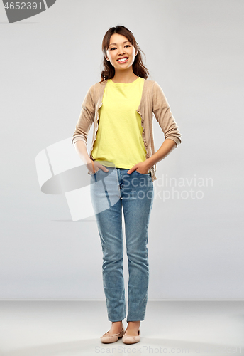 Image of happy asian woman over grey background