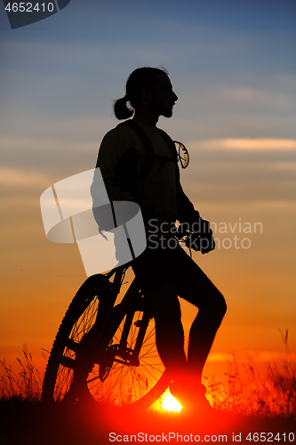 Image of silhouette of the cyclist riding a road bike at sunset