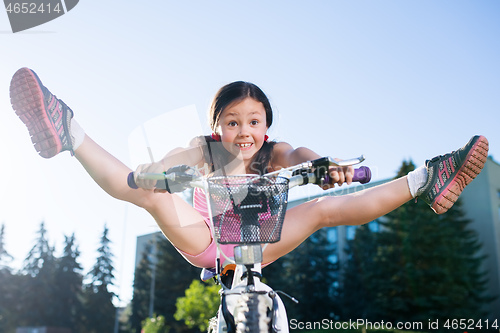 Image of Portrait of funny girl in pink clothes on her bike