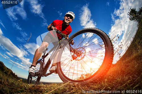 Image of cyclist riding a bike on nature trail in the mountains.