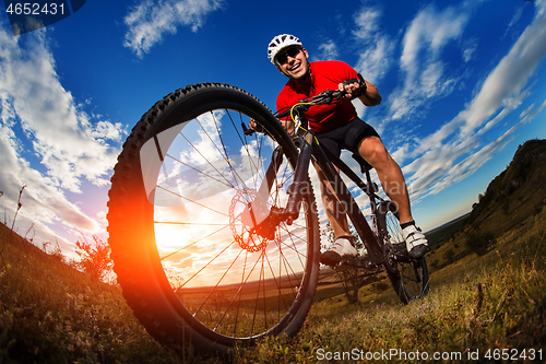 Image of cyclist riding a bike on nature trail in the mountains.