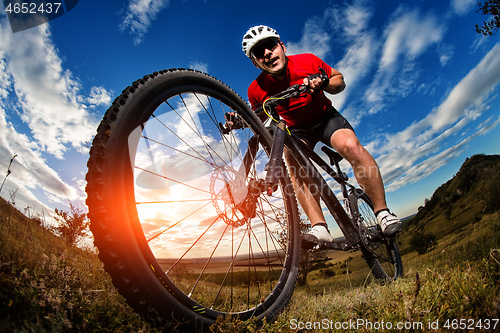 Image of cyclist riding a bike on nature trail in the mountains.