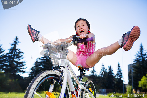 Image of Portrait of funny girl in pink clothes on her bike