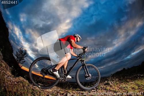 Image of cyclist riding a bike on nature trail in the mountains.