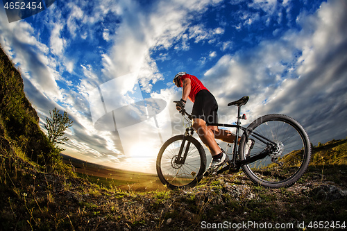 Image of cyclist riding a bike on nature trail in the mountains.