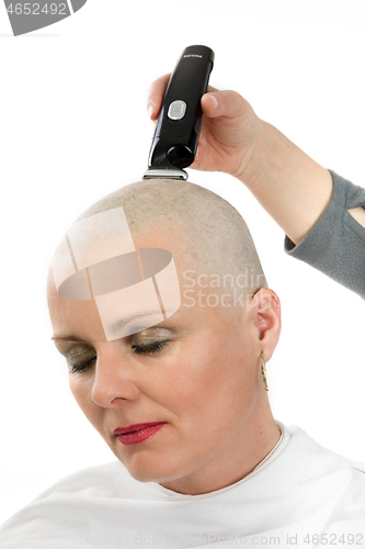 Image of beautiful iddle age woman cancer patient shaving hair