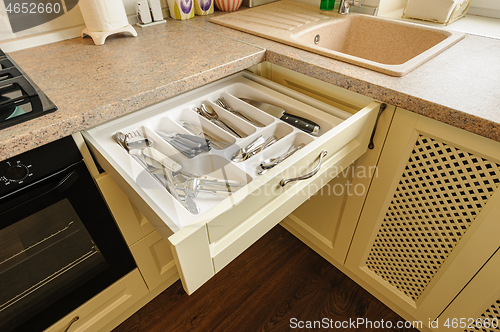 Image of open kitchen drawer with silverware inside