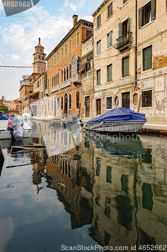 Image of Venice, Italy. Tourists walking at sidewalks aside to canals in historic part of the city